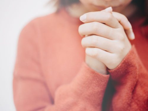 Womans hands folded in prayer
