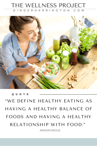 Woman in a blue shirt sits at table with healthy food.