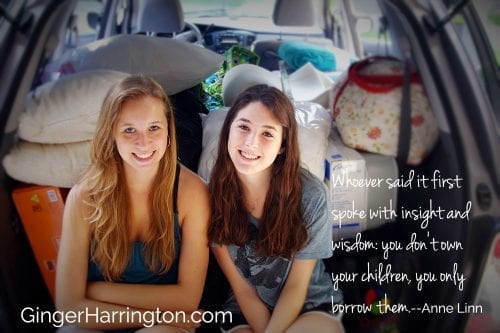 Two girls sitting in packed car ready to leave for college.