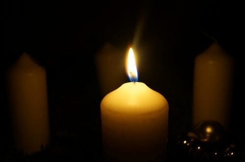 Candle burning against a dark background 