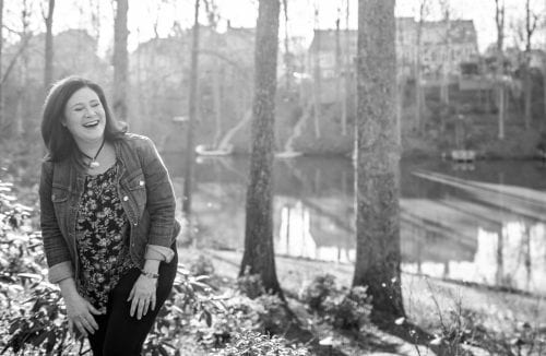 Woman laughing in the woods demonstrates a blog post on finding joy in the moment.