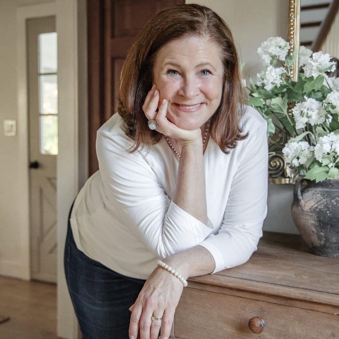 Author Ginger Harrington smiles at camera in a lifestyle shot.