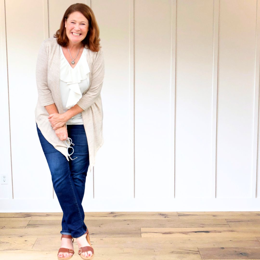 Author Ginger Harrington leans on table, holding head in her hand