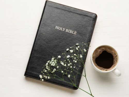 Black bible and coffe cup on a white background illustrates post on consistent quiet time with God.